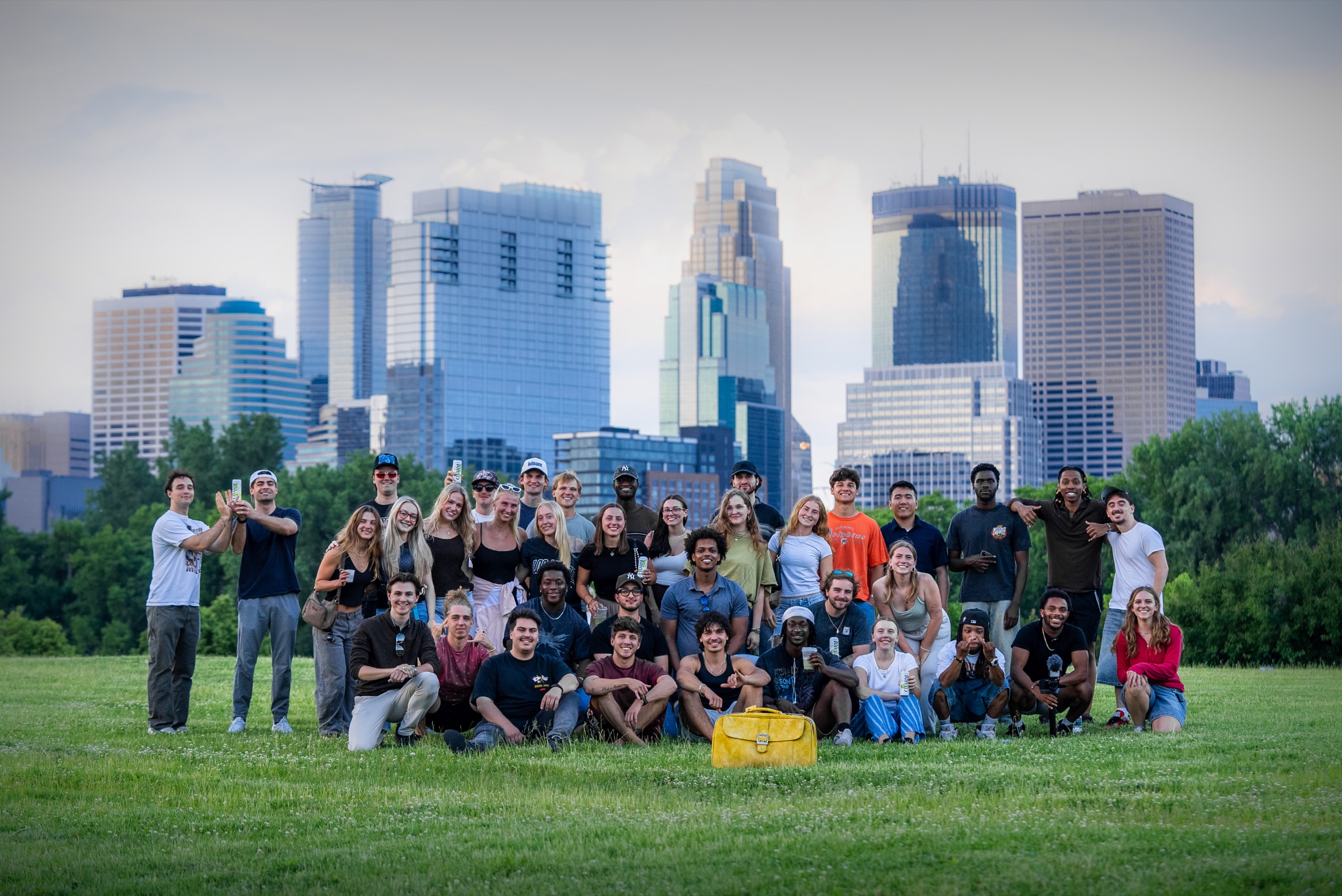 The Kids Like Us meetup group in a Minneapolis park with the city skyline behind